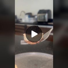 an oreo sandwich on a fork with a video play button in the middle of it