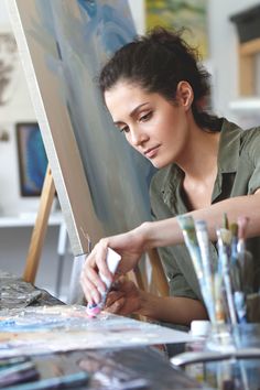 a woman is painting in an art studio