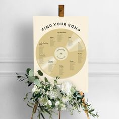 a poster with the words find your song on it next to flowers and greenery