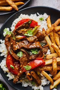 two plates filled with rice, meat and vegetables on top of each other next to french fries