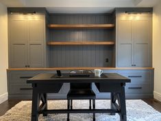 a desk with two chairs in front of it and built - in cabinets behind it