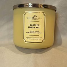 a candle that is sitting on a white surface with the label sugared lemon zest