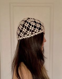 a woman with long hair wearing a white crochet headband on her head