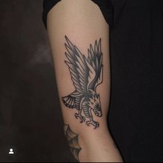 an eagle tattoo on the arm of a woman