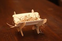 a small toy airplane sitting on top of a wooden table next to a pile of string