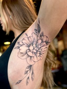 a woman's arm with a flower tattoo on the left side of her body