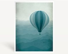 a blue hot air balloon flying over mountains