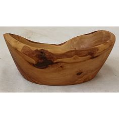 a wooden bowl sitting on top of a white table