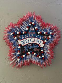 an american welcome sign with red, white and blue tinsels hanging on the wall