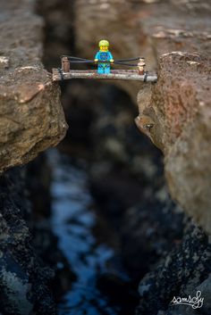 a small toy is sitting on a bridge over water