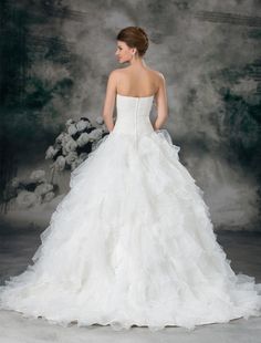 a woman in a white wedding dress standing next to flowers