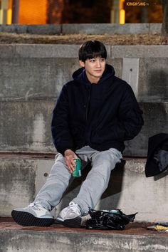 a young man sitting on the steps with his feet up