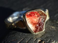 Handmade raw gemstone ring with a genuine Oregon sunstone crystal, set on a 14k gold and silver ring band. Organic and unique engagement ring, and perfect to be worn every day. Also a gorgeous gift for your anniversary, a beloved person or just to keep for yourself. > genuine uncut Oregon sunstone with a red and champagne color > 14k gold and sterling silver ring band > fits a size 8 1/4 but can be slightly upsized. This gemstone is a AA-quality, genuine Oregon sunstone, 3.12 carats in weight. I Sunstone Gemstone Jewelry As Gift, Unique Untreated Yellow Gold Jewelry, Gold Jewelry With Raw Stone For Promise Ring, Silver Sunstone Jewelry With Gemstone, Unique Untreated Ring Jewelry, Sterling Silver Wedding Rings With Raw Stone, Wedding Rings With Raw Stone In Sterling Silver, Unique Raw Jewelry For Gifts, Unique Raw Stone Ring Jewelry