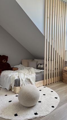 there is a teddy bear sitting on the floor in this attic bedroom with white carpet