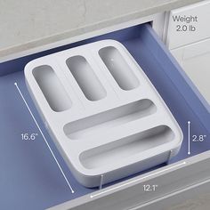 an open drawer with compartments and measurements for different items on the bottom, including two separate trays