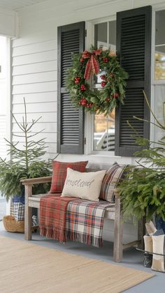 the front porch is decorated for christmas with wreaths and greenery