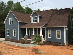 a blue house in the middle of a wooded area