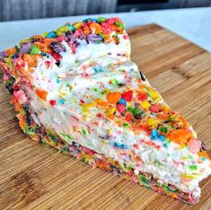 a piece of cake with sprinkles on it sitting on a cutting board