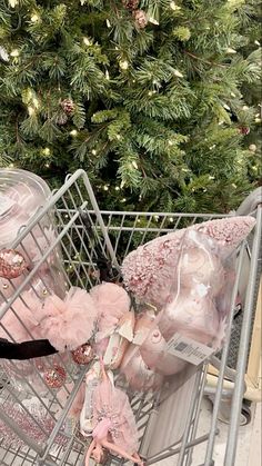 a shopping cart filled with lots of stuff next to a christmas tree