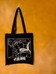 "Everyone's favourite, and strongest Jujutsu sorcerer. Printed using vinyl on durable, black tote bag. Image has been edited. Disclaimer: I do not own Jujutsu Kaisen. Dimensions: 13.3\" X 15.3\" 9.4\" straps Does not ship to Germany." Anime Print Bags For Everyday Use, Black Rectangular Bag With Anime Print, Black School Bags With Anime Print, Anime Style Black Bags For Everyday Use, Anime Style Black School Bag, Black Rectangular Bags For Cosplay, Black Rectangular Canvas Bag With Graphic Print, Black Shoulder Bag With Graphic Print For Daily Use, Black Graphic Print Shoulder Bag For Daily Use