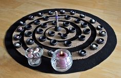 a black mat with candles and rocks on it