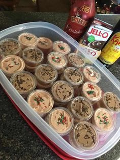 a plastic container filled with cupcakes on top of a counter next to other items