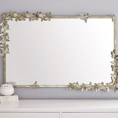 a mirror sitting on top of a white dresser