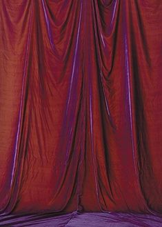 an image of a red curtain that is closed up in the dark room with purple lighting