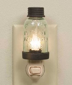 a mason jar light is mounted on a wall with a switch plate in the shape of an electrical outlet