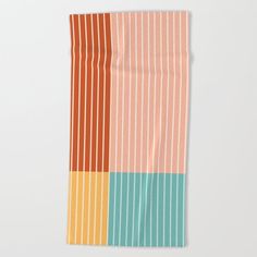 a multicolored striped towel on a white surface with the colors of orange, blue, and green