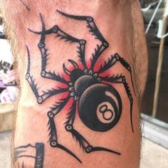 a man with a spider tattoo on his leg holding a pool ball in front of him