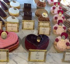 a table topped with lots of different types of cupcakes and pastries on display