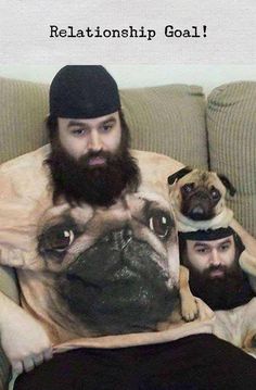 two pug dogs sitting on top of a couch next to a man with a beard