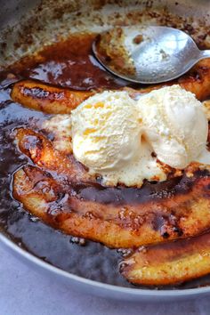 bananas and ice cream in a skillet with syrup on the side, ready to be eaten