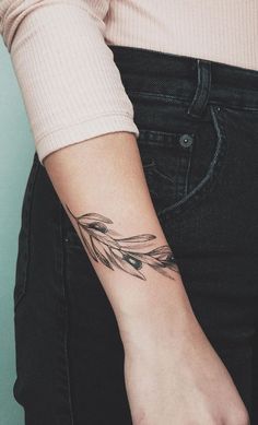 a woman's arm with an arrow tattoo on it