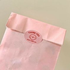 a pink bag with a thank you sticker on it