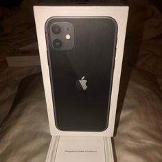 an apple iphone 11 in its box on the bed with it's lid open