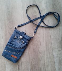 a cell phone case made out of jeans is laying on the floor with a lanyard