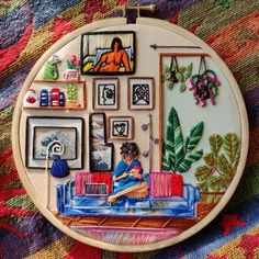 an embroidery art piece with a woman sitting on a couch