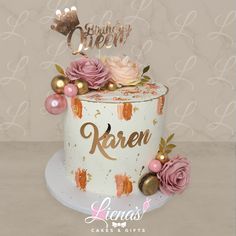 a birthday cake decorated with pink flowers and gold letters that spell it's queen