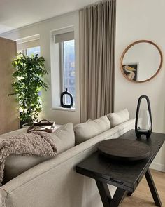 a living room filled with furniture and a large mirror on the wall next to a window