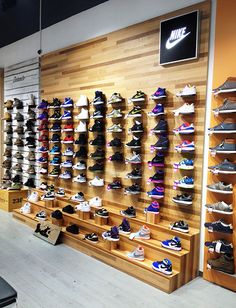 the inside of a shoe store with many pairs of shoes on display