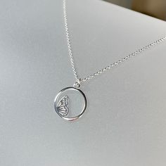 Butterfly circle pendant necklace in sterling silver This beautiful minimalist necklace features a two-sided circle pendant with a detailed half butterfly (side view) sitting within it.  The pendant is suspended on a delicate but durable sterling silver chain and is completed with a lobster claw clasp.   Butterflies are said to be a symbol of rebirth, change, renewal, good luck and beauty.  Dainty and minimal, this necklace is perfect on its own or as a layering piece. Details: necklace length:  please choose at check-out sterling silver pendant: 13 mm sterling silver chain & clasp Thanks for visiting ! Back to my shop for more jewelry options: www.etsy.com/shop/krisatdesigns Elegant Silver Round Butterfly Necklace, Delicate Silver Butterfly Necklace With Clavicle Chain, Minimalist White Gold Butterfly Jewelry, Delicate Silver Butterfly Necklace, Silver Delicate Butterfly Necklace, Silver Delicate Butterfly Necklace With Delicate Chain, Silver Butterfly Necklace With Delicate Chain, Silver Sterling Butterfly Necklace With Clavicle Chain, Minimalist Sterling Silver Butterfly Necklace With Clavicle Chain