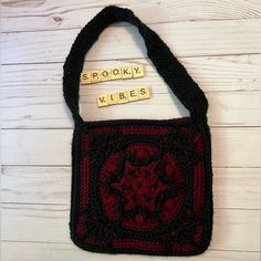 a crocheted bag with scrabbles and words written on the side