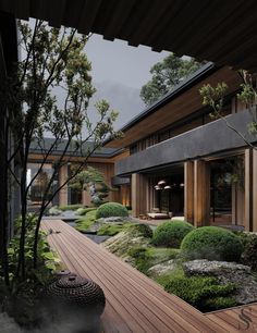 an outdoor area with wooden decking and green plants on the side of the building