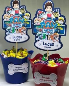 two red buckets filled with candy sitting next to each other on top of a table