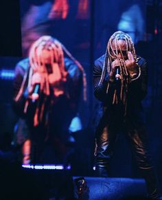 a man with dreadlocks standing on stage