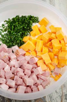 ham, cheese and parsley in a bowl on top of a wooden table next to other ingredients