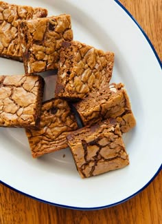 a white plate topped with brownies on top of a wooden table