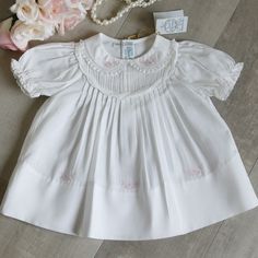 This Newborn Dress From Feltman Brothers Is Stunning! The All White Cotton Blend Dress Has A Peter Pan Collar That Is Trimmed In A Sweet Delicate French Lace That Is Attached By Faggoted Stitching (A Very High-End Detail). Both Sides Are Adorned With Lovely Pink Floral Embroidered Vines. The Front Has A Yoke Done Entirely In Petite Hand-Stitched Pin Tucks And Is Finished Off With Two Braided White Bands That Are Also Attached To Each Other By Faggoting Stitching. Beneath The Yoke Are Larger Pin Fitted Baptism Dress With Embroidered Short Sleeves, Embroidered Fitted Cotton Baptism Dress, Fitted Embroidered Cotton Baptism Dress, Short Sleeve Dresses With Floral Embroidery For Playtime, White Embroidered Dress For Playtime, Classic White Embroidered Dress, Embroidered Vines, Feltman Brothers, White Floral Lace Dress